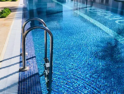 a swimming pool with a hand rail in the water at Marbella Beach location pour famille 2 chambres in Mansouria
