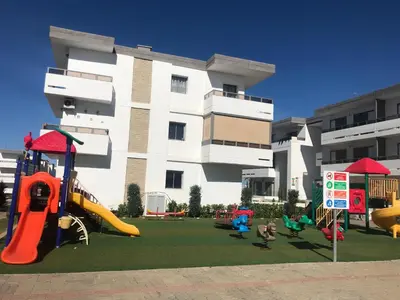 a playground in front of a building with slides at Marbella Beach location pour famille 2 chambres in Mansouria