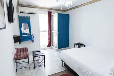 a bedroom with a bed and a blue door at Hotel Moroccan House Casablanca in Casablanca
