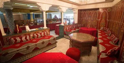 a room with red chairs and a table in a library at Hotel Moroccan House Casablanca in Casablanca