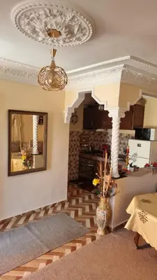 a living room with a chandelier and a kitchen at Location Vacances Casablanca Tamaris in Casablanca