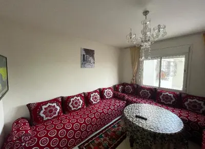 a living room with a red couch and a table at Appartement in Casablanca close to the beach in Casablanca