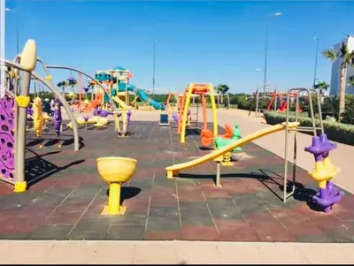a park with a playground with slides and rides at Appartement Blanca Beach in Sidi Rahal