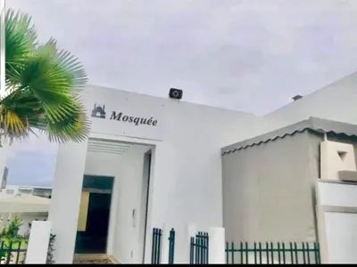 a white building with a sign on the side of it at Appartement Blanca Beach in Sidi Rahal