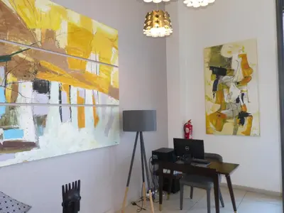 a room with a desk with a laptop and two paintings at Relax Hotel Casa Voyageurs in Casablanca