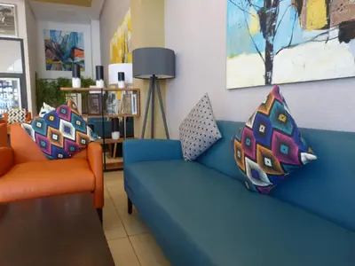 a living room with a blue couch and two orange chairs at Relax Hotel Casa Voyageurs in Casablanca