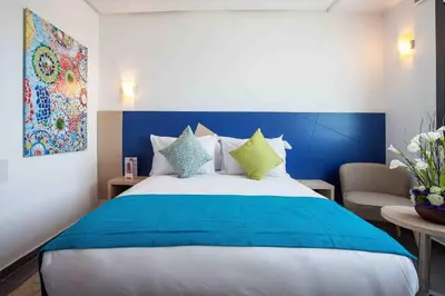 a bedroom with a large bed with a blue headboard at Relax Hotel Casa Voyageurs in Casablanca
