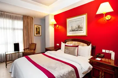 a hotel room with a red wall with a bed at Hôtel Les Saisons in Casablanca