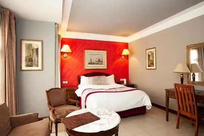 a hotel room with a bed and a red wall at Hôtel Les Saisons in Casablanca