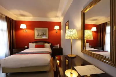 a hotel room with two beds and a mirror at Hôtel Les Saisons in Casablanca