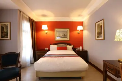a bedroom with red walls and a large bed at Hôtel Les Saisons in Casablanca