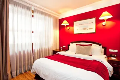 a red bedroom with a bed and a red wall at Hôtel Les Saisons in Casablanca