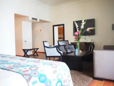 a room with a bed and a table with a vase of flowers at Park Suites Hotel Luxury Boutique Hotel in Casablanca