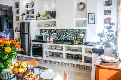 a kitchen with white cabinets and a table with fruits at Appartement moderne moroccan/African décoration in Casablanca