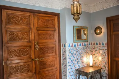 a bathroom with a wooden door and a table with a candle at Appartement moderne moroccan/African décoration in Casablanca