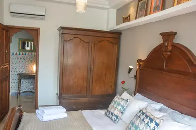 a bedroom with a bed with a wooden headboard at Appartement moderne moroccan/African décoration in Casablanca