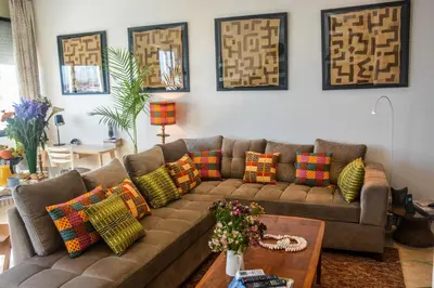 a living room with a brown couch with colorful pillows at Appartement moderne moroccan/African décoration in Casablanca