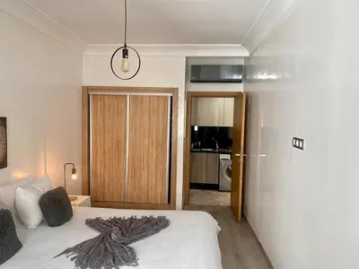 a bedroom with a bed and a sliding glass door at Appartement les pieds dans l'eau WELCOME STAY in Mohammedia