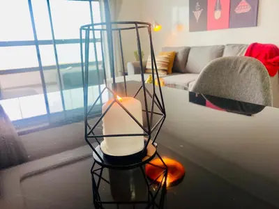 a candle in a stand in a living room at Appartement les pieds dans l'eau WELCOME STAY in Mohammedia