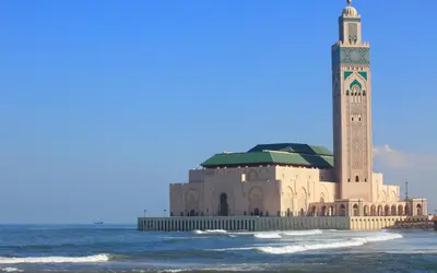 a building with a clock tower on the beach at Casablanca Home Stay Apartment in Casablanca