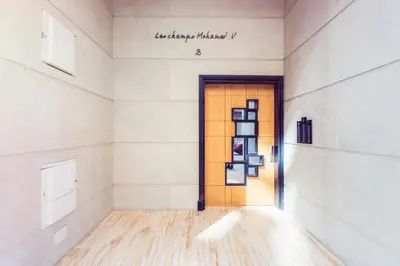 a hallway with a door with a sign on the wall at Casablanca Home Stay Apartment in Casablanca