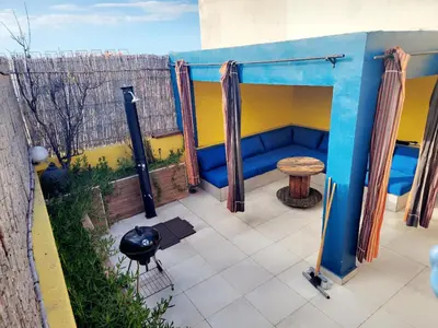 a patio with a blue couch and a table at Casablanca Home Stay Apartment in Casablanca