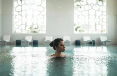 a woman in the water in a swimming pool at The View Bouznika in Bouznika