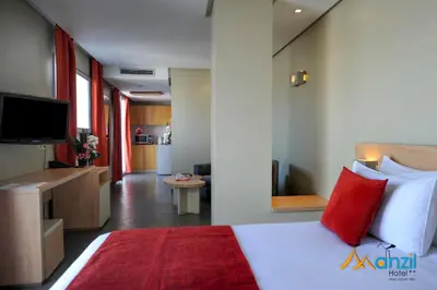 a bedroom with a large white bed with red pillows at Manzil Hotel in Casablanca