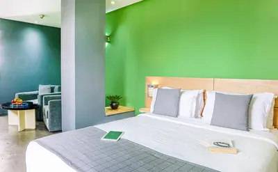 a bedroom with a large bed with a green wall at Manzil Hotel in Casablanca
