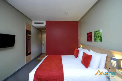 a bedroom with a large bed with a red wall at Manzil Hotel in Casablanca