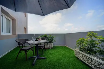 a patio with a table and chairs and green grass at Golden Star Casablanca in Casablanca
