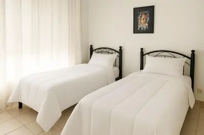 two beds with white sheets in a room at Appartement Hay Riad in Rabat