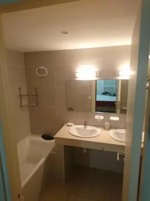 a bathroom with two sinks and a tub and a mirror at Appartement Hay Riad in Rabat