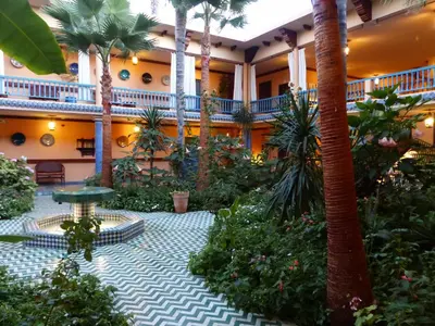 a courtyard in a hotel with palm trees and plants at La Villa Mandarine in Rabat
