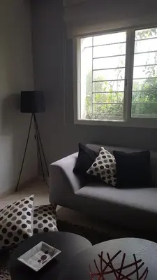 a living room with a couch and a window at Residence les Pins in Rabat