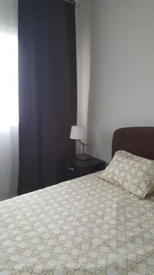 a bedroom with a bed and a lamp on a table at Residence les Pins in Rabat