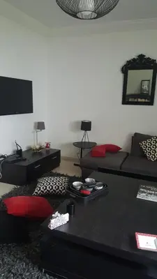 a living room with a couch and a tv at Residence les Pins in Rabat