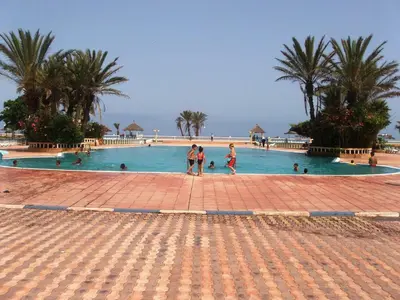 a large swimming pool with people in the water at Appartement Palm Beach in Mohammedia