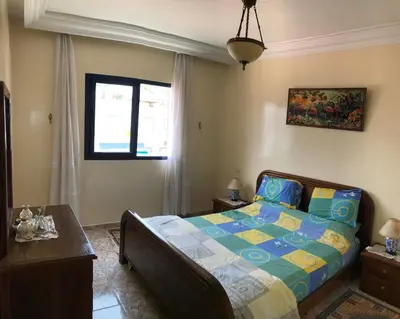 a bedroom with a bed and a window at Appartement Palm Beach in Mohammedia