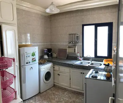 a kitchen with a white refrigerator and a dishwasher at Appartement Palm Beach in Mohammedia