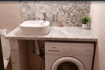 a bathroom with a sink and a washing machine at Appartement Tamaris couple mariés in Tamaris