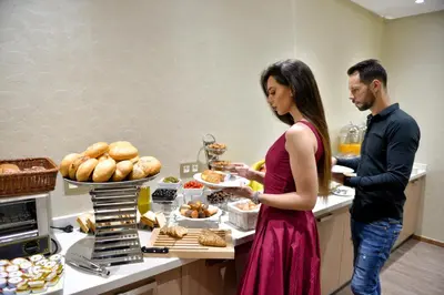 a man and a woman standing in a kitchen preparing food at Le 22 Appart'Hotel in Casablanca