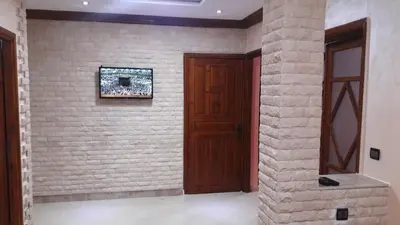 a room with a brick wall with a wooden door at Joudia in Temara
