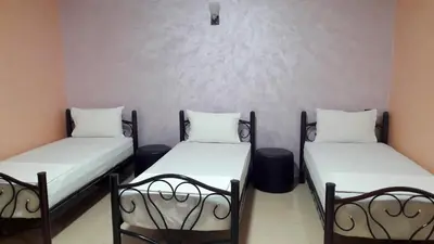 a room with two beds and two trash cans at Joudia in Temara