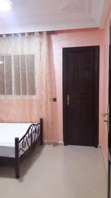 a bedroom with a bed and a black door at Joudia in Temara