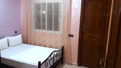 a bedroom with a bed with a window and a door at Joudia in Temara