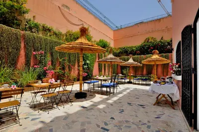 a patio with tables and chairs and umbrellas at LHOSTEL à Casablanca in Casablanca