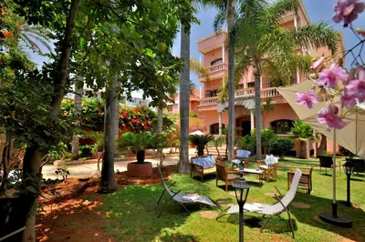 a courtyard with chairs and tables and palm trees at LHOSTEL à Casablanca in Casablanca