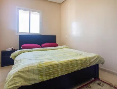 a bedroom with a bed with two pillows and a window at Res Mario 3 Lovely Apartment With Balcony & Sea View Free Wifi in Casablanca