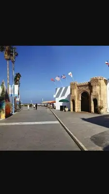 a building with flags on top of it on a street at Res Mario 3 Lovely Apartment With Balcony & Sea View Free Wifi in Casablanca